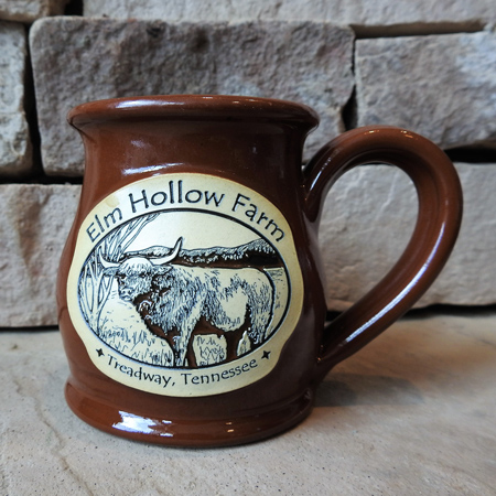 Ten ounce belly mug with cinnamon color glaze and embossed logo of Elm Hollow Farm